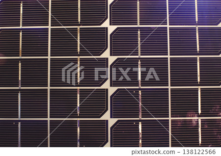 A horizontal macro top-down view of the repetitive pattern of solar cells. The image shows the dark blue silicon surface and the thin silver conductive grid. 138122566