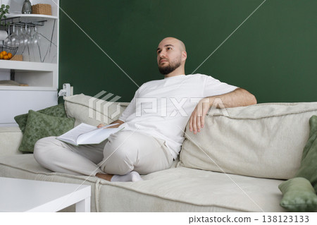Sitting man resting at home and reading a book 138123133
