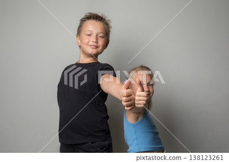 boy and girl smiling and showing thumb up boy and girl smiling and showing thumb up 138123261