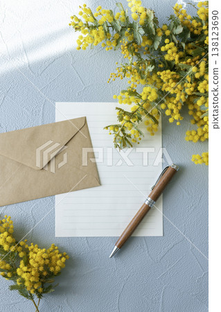 Spring letter materials featuring mimosa, envelopes, stationery, and pens, with a blue background and copy space. 138123690