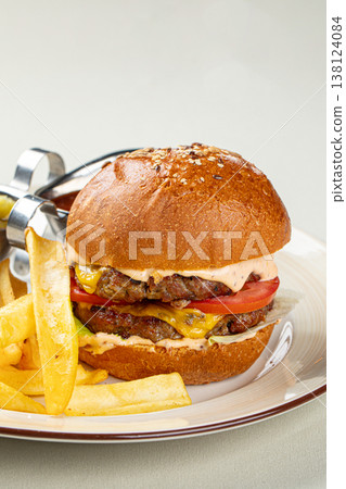 Juicy burger with fries and pickles on plate Juicy burger with fries and pickles on plate 138124084