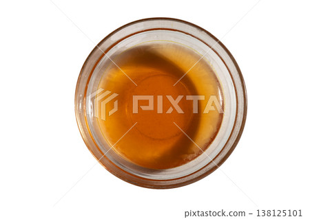 Amber viscous syrup texture in transparent glass bowl macro shot Amber viscous syrup texture in transparent glass bowl macro shot 138125101