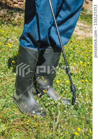 a man applies herbicide at ground level a man applies herbicide at ground level 138125353