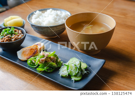 A Japanese breakfast spread served on a long plate: Cucumber and whitebait salad with bell peppers and grilled mochi. A Japanese breakfast spread served on a long plate: Cucumber and whitebait salad with bell peppers and grilled mochi. 138125474