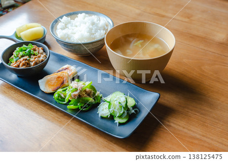 A Japanese breakfast set with natto and a small side dish, served on a wooden table. A Japanese breakfast set with natto and a small side dish, served on a wooden table. 138125475