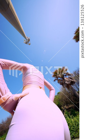 Person in pink bodysuit flawlessly aligns spine during outdoor yoga session Person in pink bodysuit flawlessly aligns spine during outdoor yoga session 138125526