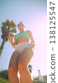Lady performing highenergy cardio along sunny coastal promenade 138125547