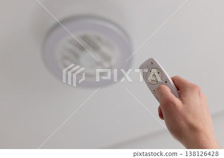 Man turns on the lamp with fan. Selective focus, closeup. 138126428