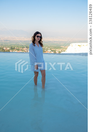Relaxing in the Turquoise Thermal Waters of Pamukkale at Sunset With a Stunning View of the Surrounding Landscape 138126489