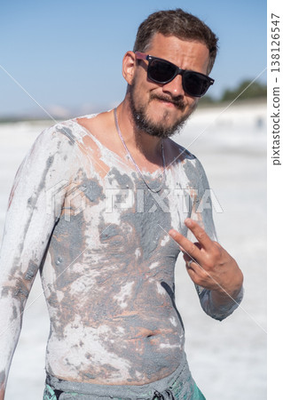 Man Enjoying Mud Therapy at a Natural Spa Location Under Bright Sunlight 138126547