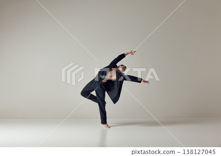 Dancer balancing on one leg with extended arms in clean studio space Dancer balancing on one leg with extended arms in clean studio space 138127045