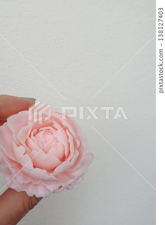 Delicate handmade soap with pink flowers held in hand Delicate handmade soap with pink flowers held in hand 138127403