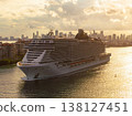 Large passenger cruise ship departing Miami port at sunset. Scenic view of South Beach waterfront with high-rise hotels and residential towers. 138127451