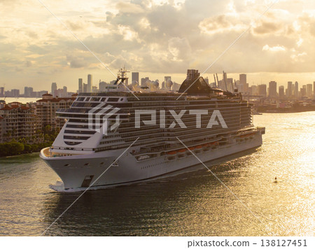 Large passenger cruise ship departing Miami port at sunset. Scenic view of South Beach waterfront with high-rise hotels and residential towers. Large passenger cruise ship departing Miami port at sunset. Scenic view of South Beach waterfront with high-rise hotels and residential towers. 138127451