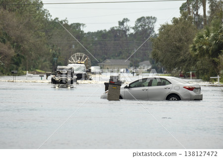 Hurricane flooded street with broken car in surrounded with water Florida residential area. Consequences of natural disaster Hurricane flooded street with broken car in surrounded with water Florida residential area. Consequences of natural disaster 138127472