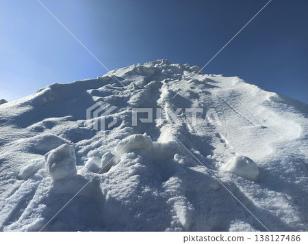 High pile of white snow on winter sunny day. High pile of white snow on winter sunny day. 138127486