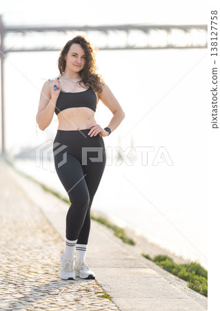 Young woman posing outdoors holding skipping rope 138127758