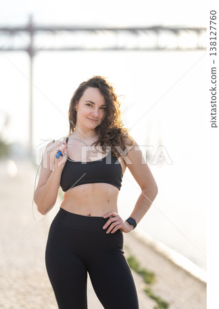 Young woman smiling holding jump rope during fitness workout 138127760