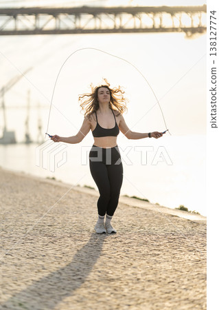 Woman exercising outdoors with skipping rope for fitness Woman exercising outdoors with skipping rope for fitness 138127774