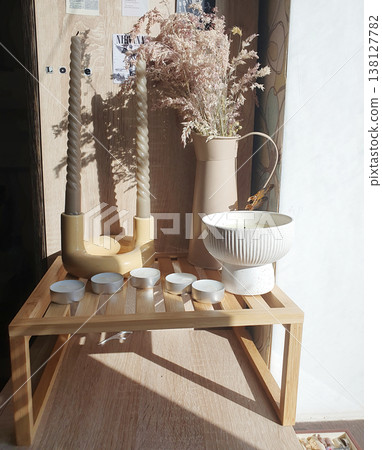 Cozy home decor with white tea light candles, twisted candles in a holder, and pampas grass. Warm morning sunlight Cozy home decor with white tea light candles, twisted candles in a holder, and pampas grass. Warm morning sunlight 138127782