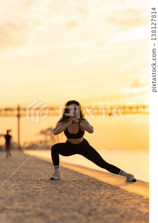 Woman exercising lunge during fitness workout at sunrise Woman exercising lunge during fitness workout at sunrise 138127814