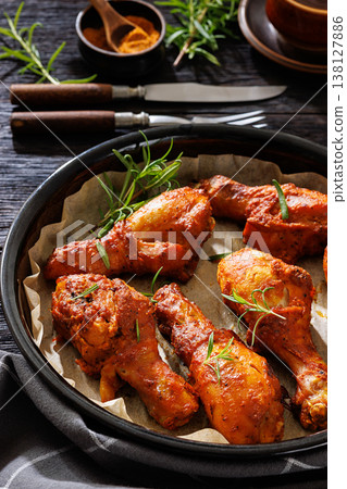 Roasted chicken drumsticks on paper in baking dish Roasted chicken drumsticks on paper in baking dish 138127886