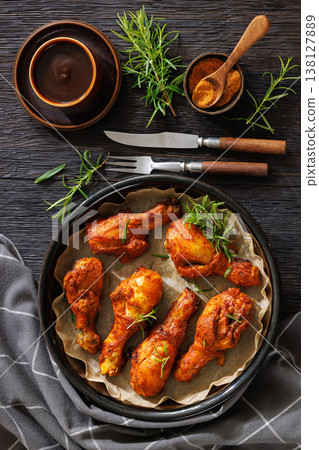 Roasted chicken drumsticks on paper in baking dish Roasted chicken drumsticks on paper in baking dish 138127889