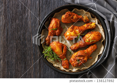 Roasted chicken drumsticks on paper in baking dish Roasted chicken drumsticks on paper in baking dish 138127892
