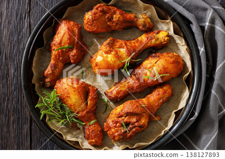 Roasted chicken drumsticks on paper in baking dish Roasted chicken drumsticks on paper in baking dish 138127893