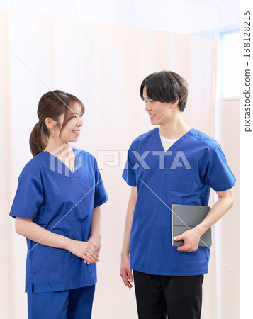 年輕的男女醫護人員在聊天微笑。 年輕的男女醫護人員在聊天微笑。 138128215
