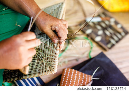 Hands of Indigenous Mangyan Woman Carefully Weaving a Traditional Basket from Bamboo Fibers in Mangyan Village, Talipanan, Puerto Galera, Oriental Mindoro, Philippines 138128734