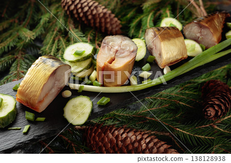 Smoked mackerel with fresh cucumber and green onions on a black plate. Smoked mackerel with fresh cucumber and green onions on a black plate. 138128938