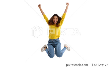 A joyful person doing a small jump with arms raised, smiling brightly. Isolated on white background. 138129376