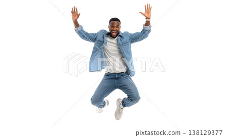 A joyful person doing a small jump with arms raised, smiling brightly. Isolated on white background. 138129377