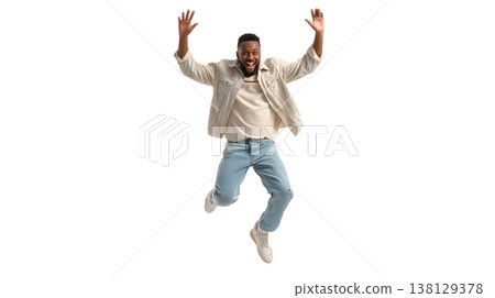 A joyful person doing a small jump with arms raised, smiling brightly. Isolated on white background. 138129378