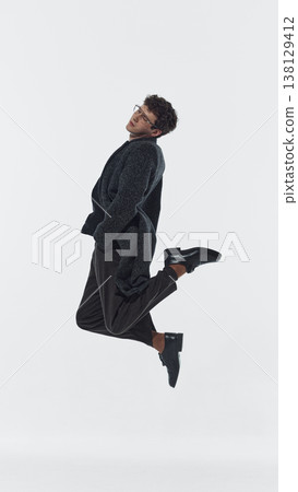 Man jumping with bent legs in studio isolated on white background Man jumping with bent legs in studio isolated on white background 138129412