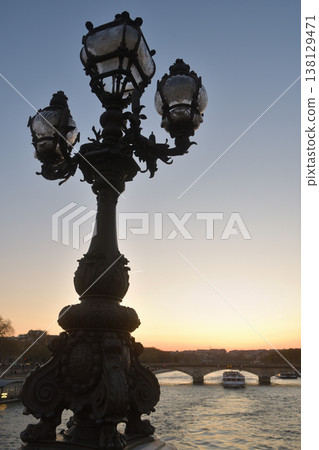 A view of the sunset and streetlights during magic hour from the Pont Alexandre III, Paris, March 18, 2026. 138129471