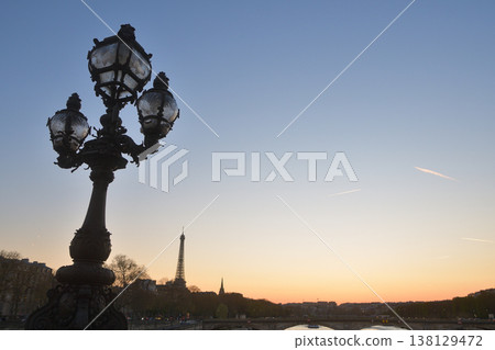 A view of the sunset and streetlights during magic hour from the Pont Alexandre III, Paris, March 18, 2026. 138129472