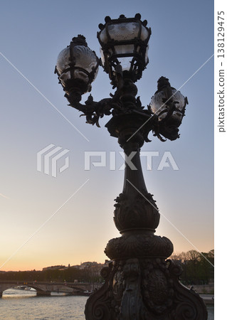 2026年3月18日，從巴黎亞歷山大三世橋上看到的日落和街燈在魔幻時刻的景象。 138129475