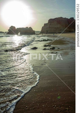 Golden hour romantic vacation beach scene big sun Algarve Portugal Praia do Amado Golden hour romantic vacation beach scene big sun Algarve Portugal Praia do Amado 138129532