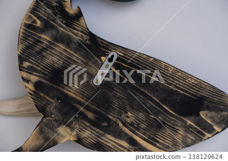 Back view of a hand-carved wooden whale sculpture, showing the natural wood grain and a metal wall mounting bracket. 138129624
