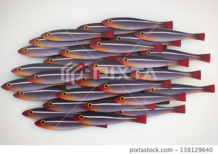 Artistic wooden wall panel featuring a school of stylized fish with purple, orange, and red gradient tones on a white background. 138129640
