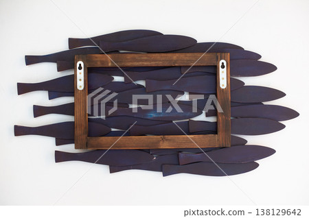 Rear view of a handcrafted wooden school of fish wall art panel, showing the mounting frame with hardware against a white background. Rear view of a handcrafted wooden school of fish wall art panel, showing the mounting frame with hardware against a white background. 138129642