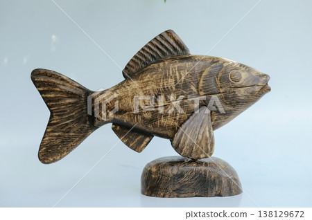Hand-carved wooden fish sculpture on a natural stone-shaped wooden base, showcasing the detailed head and deep distressed timber grain. Hand-carved wooden fish sculpture on a natural stone-shaped wooden base, showcasing the detailed head and deep distressed timber grain. 138129672