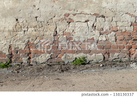 Weathered red brick wall with cracked, peeling plaster Weathered red brick wall with cracked, peeling plaster 138130337