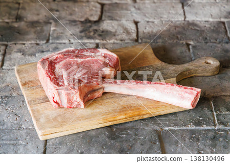 Raw tomahawk steak on cutting board Raw tomahawk steak on cutting board 138130496