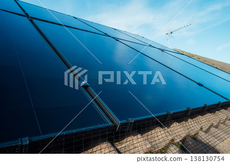 Close up solar power roof panel on Modern, energy-efficient house with blue sky background. Renewable eco Energy. Concept of economy and profit from selling excess electricity. Smart energy management Close up solar power roof panel on Modern, energy-efficient house with blue sky background. Renewable eco Energy. Concept of economy and profit from selling excess electricity. Smart energy management 138130754