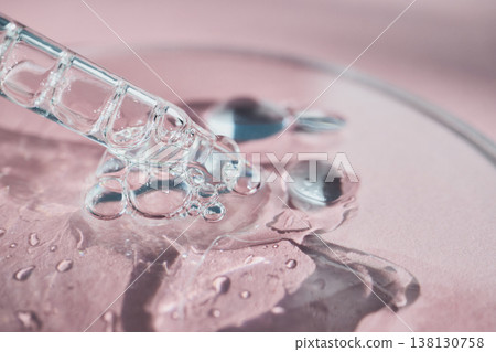 Pipette drawing clear liquid creating bubbles on pink surface Pipette drawing clear liquid creating bubbles on pink surface 138130758