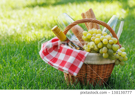Picnic basket with wine, grapes, and baguette 138130777