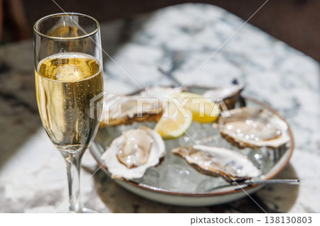Fresh oysters on ice with champagne in sunlight Fresh oysters on ice with champagne in sunlight 138130803